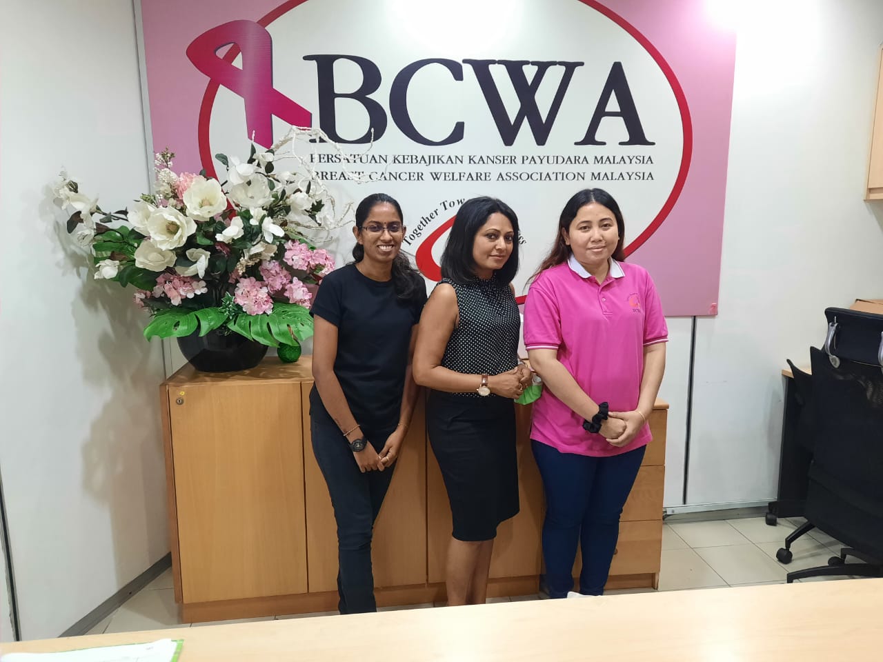 Simran (middle) at work with another breast cancer association.